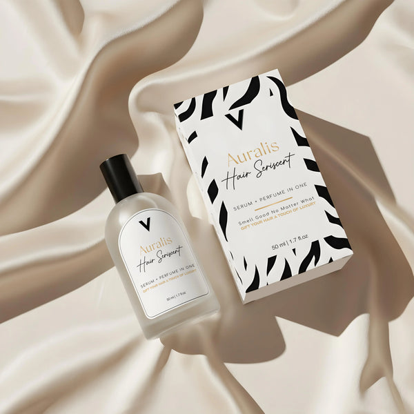 Auralis Hair Serum bottle and packaging on a beige fabric background